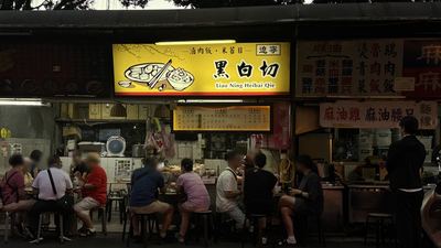 黑白切の屋台。カウンターに客が並ぶ夜の風景